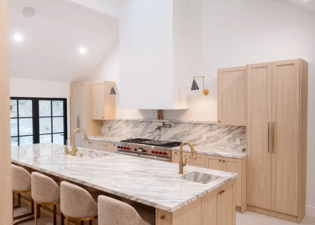 Kitchen island with stone top and counter stools under a vaulted ceiling, Bel Air Project by Home Deco