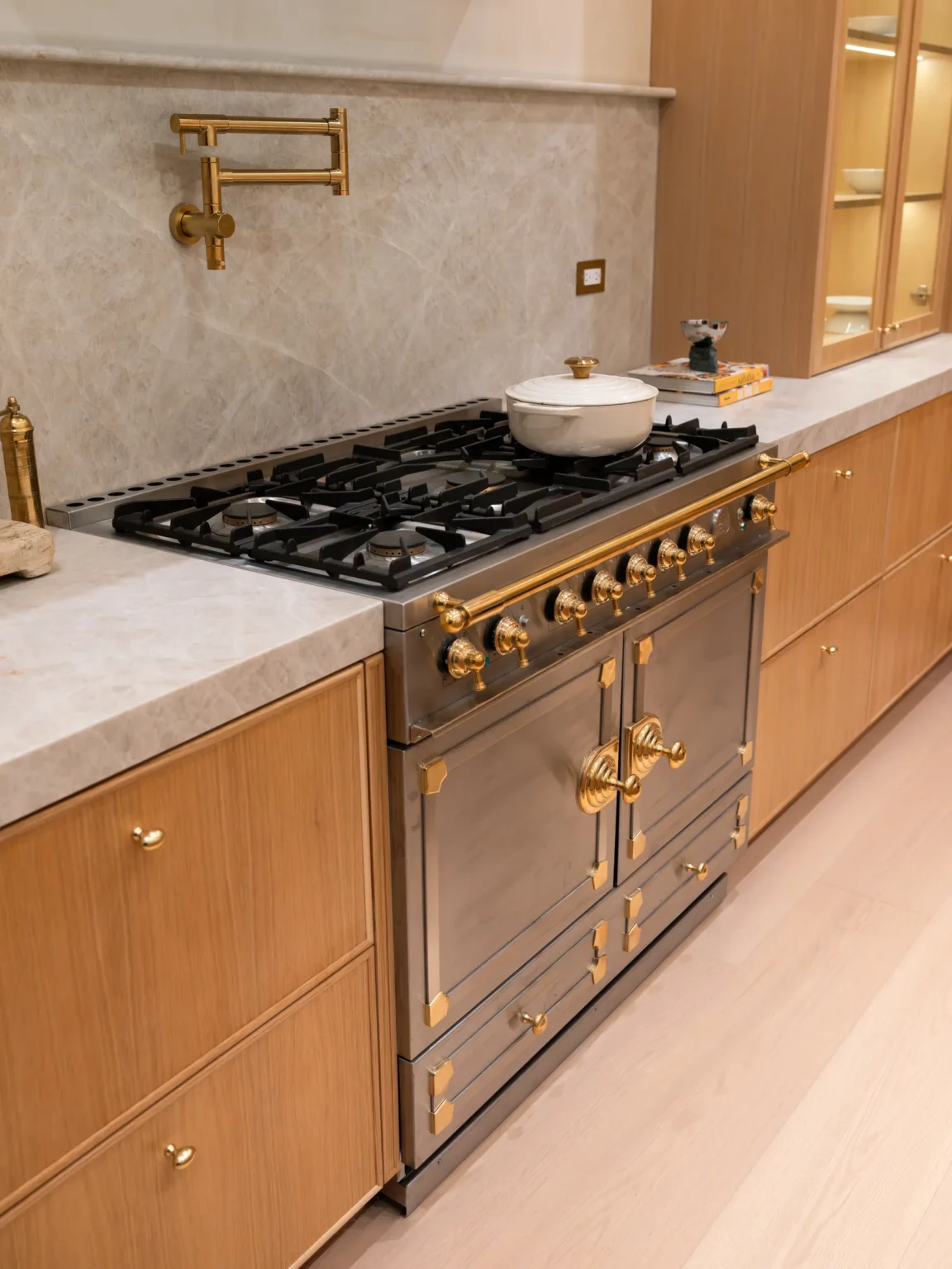 Range wall with brass pot filler and warm wood cabinetry, Dickens Project by Home Deco