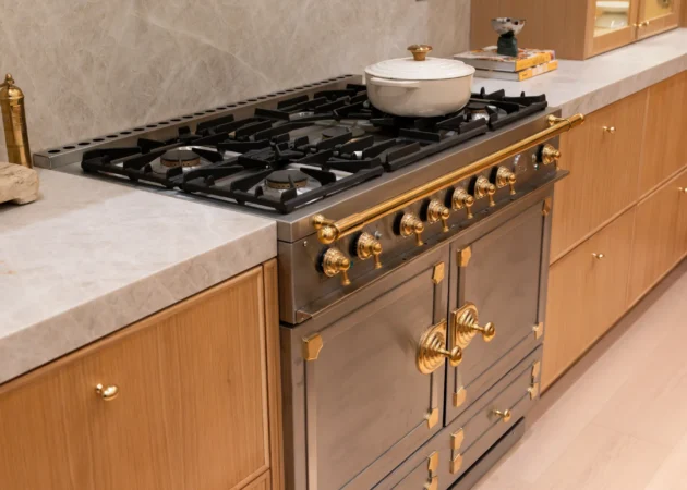 Range wall with brass pot filler and wood cabinetry, Dickens Project by Home Deco