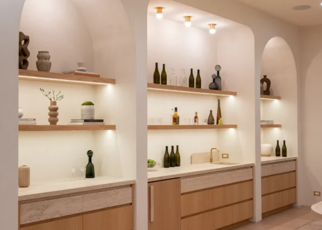 Arched bar niches with lit shelves and wood cabinets, Dickens Project by Home Deco