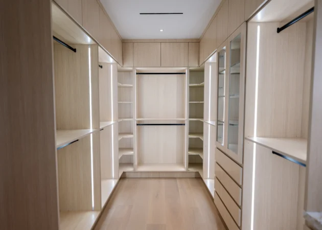 Walk-in closet with lit hanging and shelving, Lynngrove Project by Home Deco