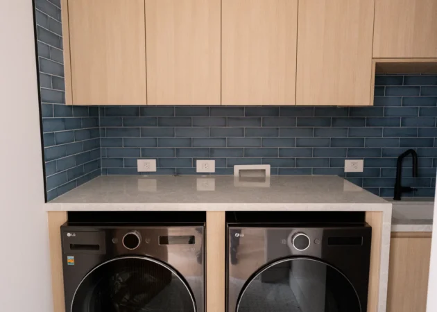 Laundry room with upper cabinets and blue tile, Lynngrove Project by Home Deco